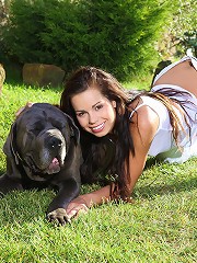 Young beautiful teen plays with her dog in the yard